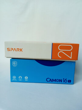 Two Tecno smartphone paper boxes package on white background. Camon 16 S and Spark 20 phone lying, stacked on top. Double Android phones with fingerprint. Kumasi, Ghana - December 9, 2025