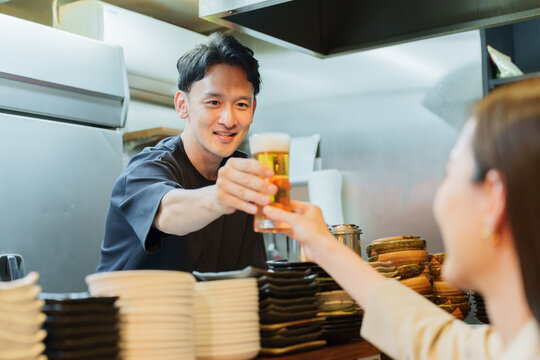 居酒屋でお客様にビールを提供する店長
