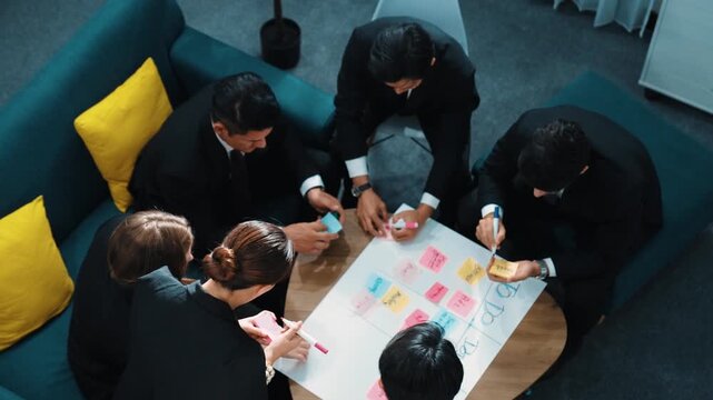 Top view of smart business team write marketing plan and putting stick notes on mind map. Group of happy business people brainstorm financial idea and planning strategy at meeting room. Directorate.