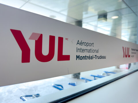 Montreal, Quebec, Canada. July 12, 2026. Angled close-up view of the YUL Montreal-Trudeau International Airport logo sign on glass.