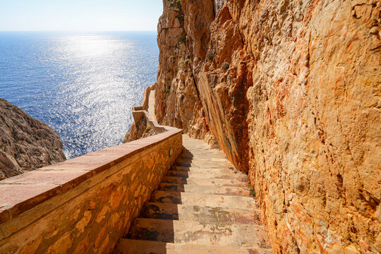 Scenic descent down the Escala del Cabirol staircase carved into the cliffs of Capo Caccia in Sardinia, Italy