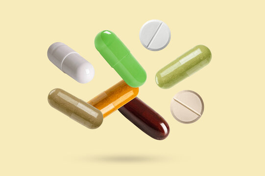Falling medicine capsules pill on pastel background.