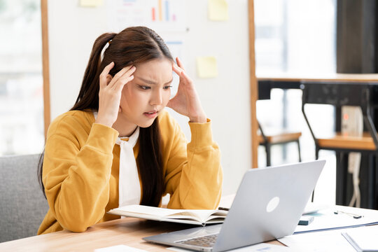 Stressed Young Woman Working on Laptop in Creative Office
