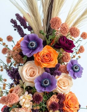 vibrant autumnal bouquet of purple anemones, orange and peach roses, maroon blooms, dried seed heads and pampas grass on a soft neutral background, elegant rustic mood