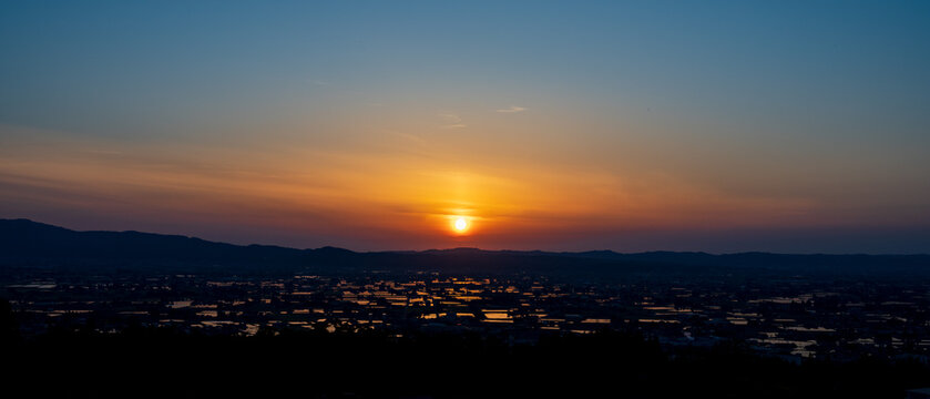High-angle sunset view of the iconic Sankyoson dispersed settlement and flooded rice paddies in Toyama, Japan
