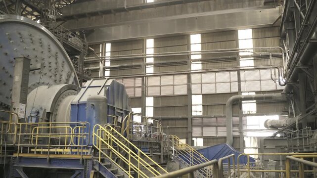 Industrial grinding mill operating inside a large copper processing facility. The footage showcases mineral processing technology, heavy machinery, and large scale mining operations.