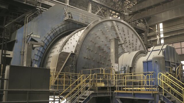 Static view of a large SAG grinding mill operating inside El Teniente copper processing facility in Chile. Industrial mining equipment used for ore grinding and mineral processing.