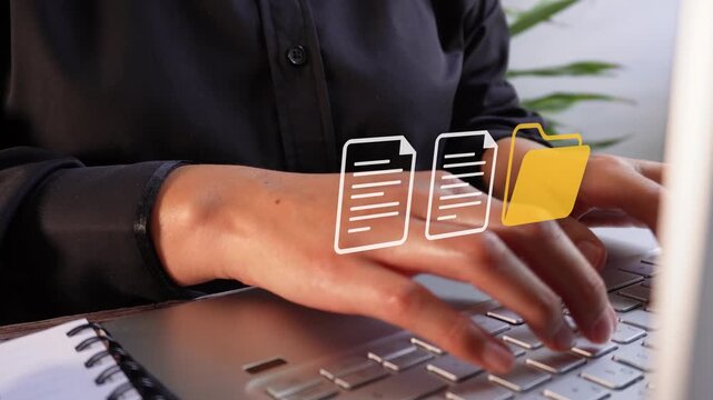 Hands type on laptop keyboard with focused intent. Digital icons float above keys, suggesting file management or data entry. Office environment with soft lighting and green plants nearby