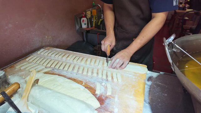 Street Food Chef Cutting Dough for Traditional Fried Bread Sticks