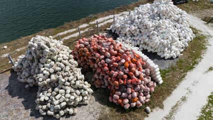 Storage yard with white and red fishing buoys near the sea. Equipment used for aquaculture and commercial fishing. © soya