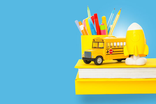 Colorful supplies and a yellow bus signify the start of school