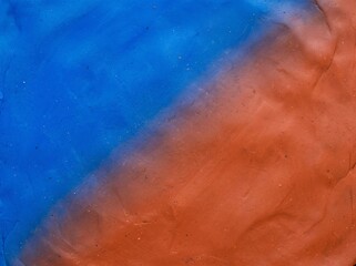 Fototapeta premium Textured Blue and Terracotta Orange Plasticine Clay Diagonal Background