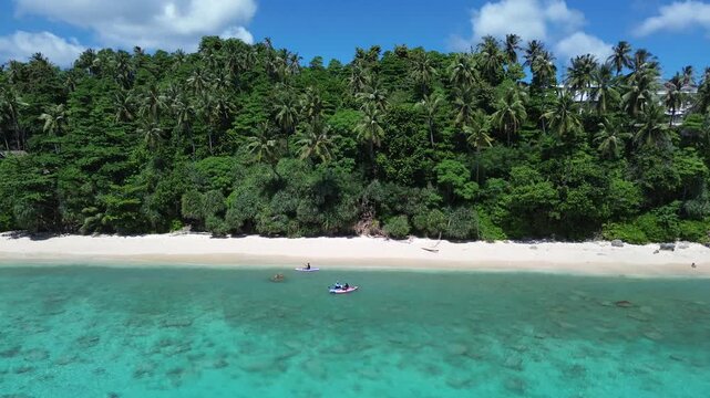 Paradise Tropical Beach with Clear Blue Water and Coconut Palms Seen from Above in Sumur Tiga Beach, Sabang, Aceh, Indonesia