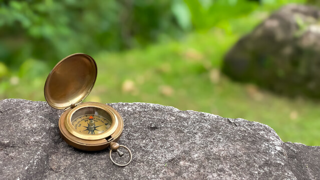 A classic brass compass on a stone with ample space for text. A symbol of life choices, strategy, leadership, planning, goals, and personal development.