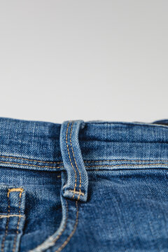 Closeup view of denim jeans showing pocket and waistband details