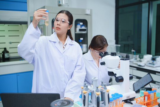 Scientist Analyzing Sample in Laboratory with Microscope