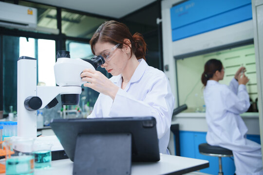 Scientist Using Microscope for Sample Analysis in Laboratory