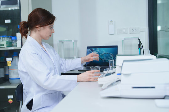Laboratory Scientist Conducting Chemical Experiment with Beakers and Glassware