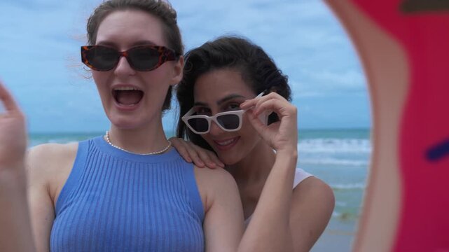 Beach summer friendship selfie swim ring donut eyewear happy ocean vacation, joyful friends by water under blue sky on shoreline sand, sea breeze and natural light, coastline cloud sky portrait waves