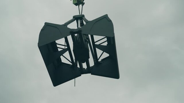 Worms eye view of a hanging crane towering above de Oude Dokken against the sky in industrial urban setting - Ghent, Belgium
