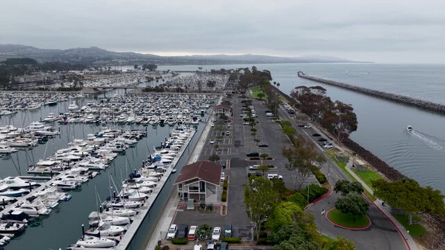 A low altitude flight above the Dana Point Harbor reveals a massive collection of boats and yachts docked closely together.