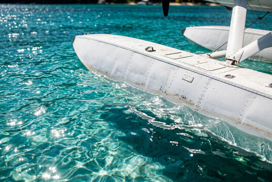 White seaplane float resting on clear turquoise tropical water