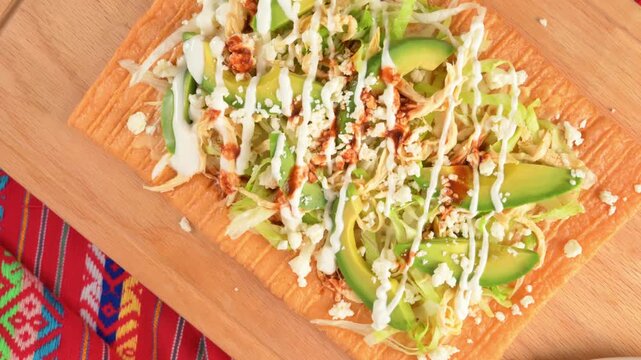 Traditional Mexican snack, crispy wheat chicharron with fresh toppings on a wooden board