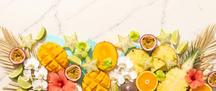 Vibrant tropical fruit flat lay display on cream marble for refreshing design