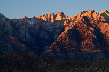 Naklejka premium Majestic sierra nevada mountain peak standing tall under bright sunset light bringing tranquil emotion across vast rock landscape and deep alpine valley
