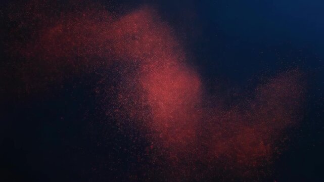 Red powder explosion particles on a dark blue background