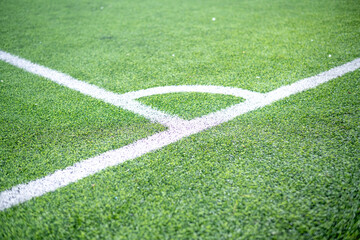Obraz premium Corner kick line on green artificial turf football field with shallow depth of field. Concept of business strategy, planning boundaries, milestone achievement, turning point, and strategic growth in c
