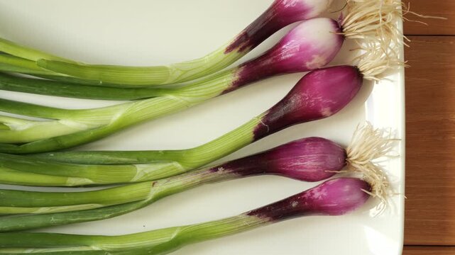 Fresh purple spring onions on white background