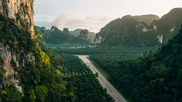 Aerial View of Highway Intersection in Vast Green Valley and Limestone Mountains