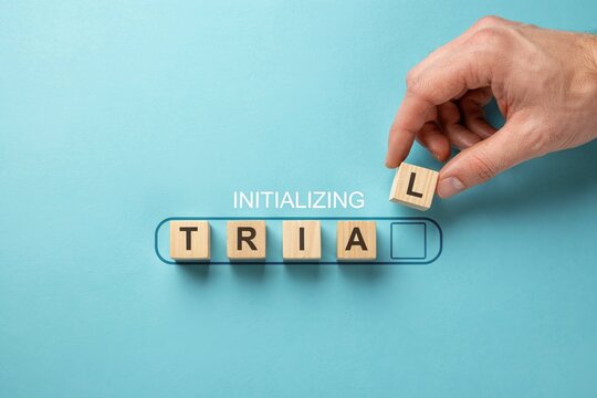 Initializing trial concept with hand placing final letter block in progress bar on blue background