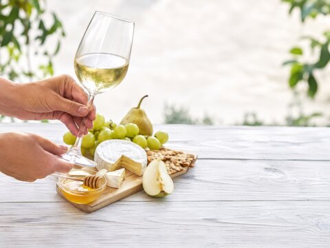Momento de degustaci&oacute;n con vino, frutas, miel y queso en una mesa al aire libre