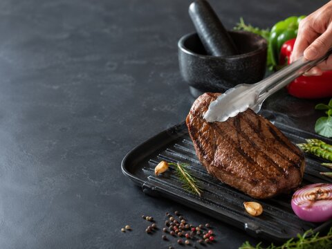 Momento de cocinar carne a la parrilla en una cocina con vegetales y especias