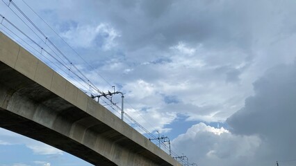 Naklejka premium Elevated concrete metro rail track under a dramatic stormy sky