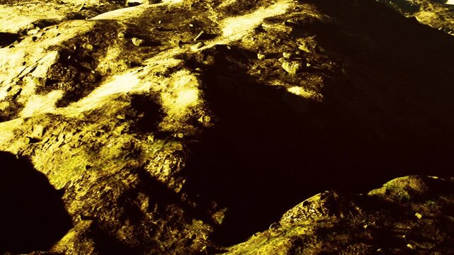 The view shows a rugged landscape with various rock formations. Sunlight casts shadows on the ground, highlighting the texture of the rocks. The scene appears desolate and barren.