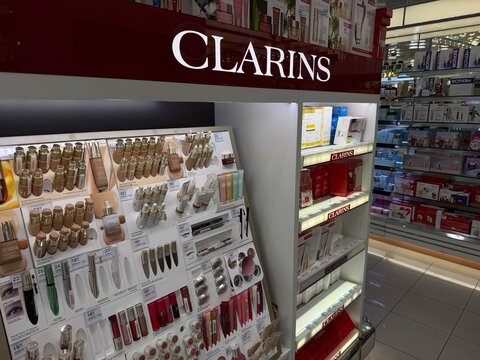 Mallorca, spain, july 06, 2026, clarins branded makeup and skincare items arranged on illuminated shelves, showcasing premium beauty products for shopping and retail concepts