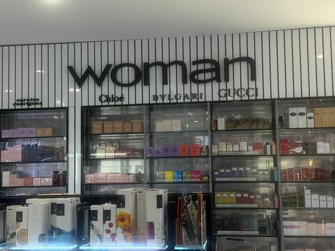 Mallorca, spain, july 06, 2026, woman sign displaying various luxury fragrance brands like chloe, bvlgari, gucci, and narciso rodriguez in a duty free shop