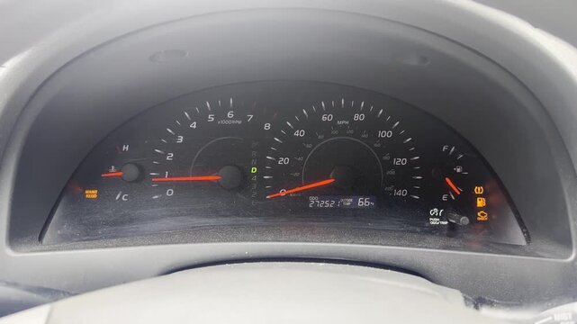 Close-up of a car instrument cluster displaying lit ABS, check engine, TPMS, and maintenance icons.
