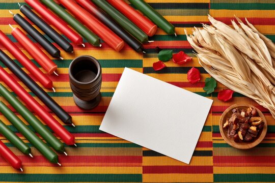 Kwanzaa flat lay with kinara candles, unity cup (kikombe cha umoja) and kente cloth mockup