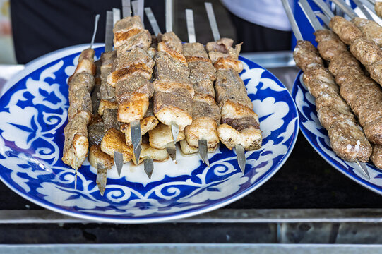 Traditional grilled kebab made from seasoned minced meat and beef skewers with tail fat displayed at a local market. Authentic charcoal barbecue and regional cuisine.
