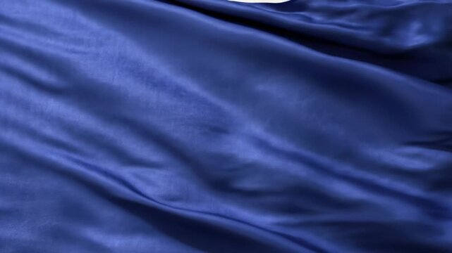Deep blue satin fabric texture with elegant folds, flowing waves, and lustrous sheen, ideal for luxurious backgrounds and elegant design elements