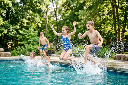 Children jumping into backyard swimming pool with splashes and joyful expressions for summer activity banner and family fun background
