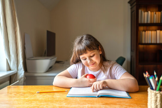 Schoolgirl studying from textbook at home