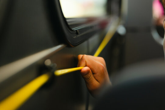 Passenger pulling bus stop request cord while riding the city bus