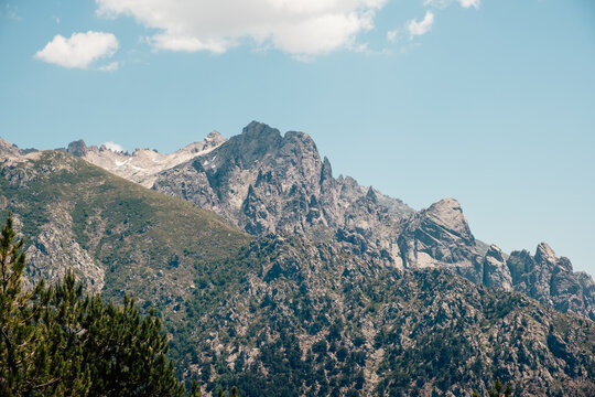 Mineral mountain landscape and steep rocky mountain range under the sky of Corsica