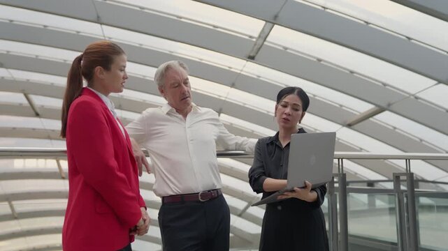 Business meeting team office laptop senior colleague discussion modern architecture professional diverse coworkers corporate planning in glass atrium workplace