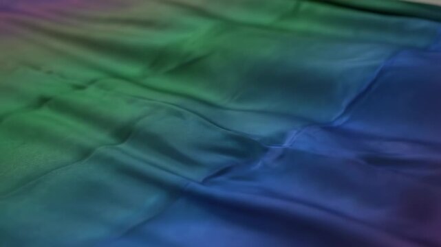 close up abstract texture background, gradient colors of green blue and purple overlay on textured fabric with stitch details, motion waves